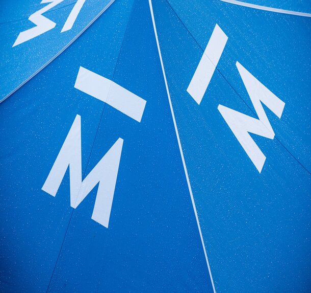 A close up shot of a steel blue canopy tent roof made from Pirontex fabric with water droplets.