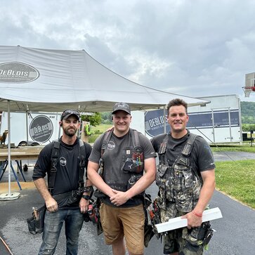 Renovation team standing in front of heavy duty Mastertent brand work tent outside at a job site. 
