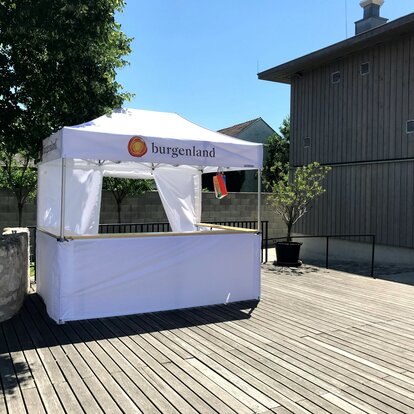 10x5ft white tent customized with logo with half-height white side walls with counter and side wall with door.