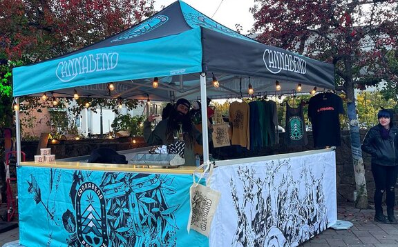 A fully printed Mastertent canopy tent set up as a sales booth.