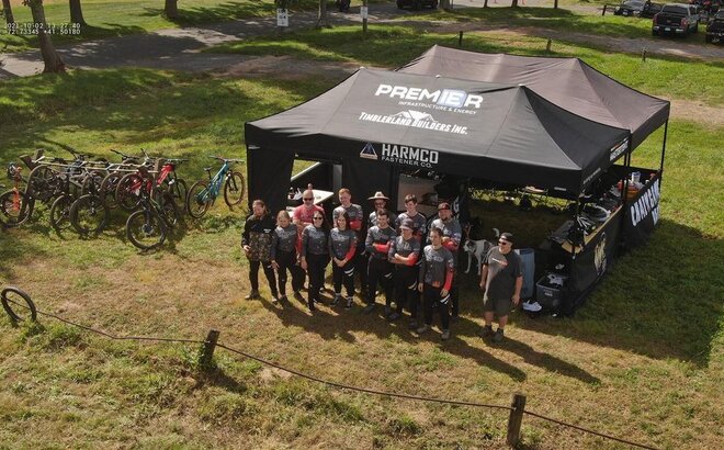 Two black canopy tents set up at a bike racing event. 