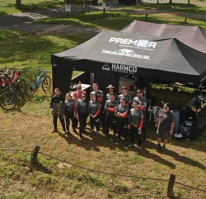 Two black canopy tents set up at a bike racing event. 