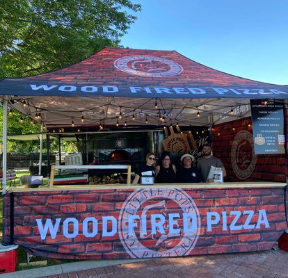 A custom 15x10 pizza tent with counters and sidewalls is used as a checkout counter and mobile food service. 