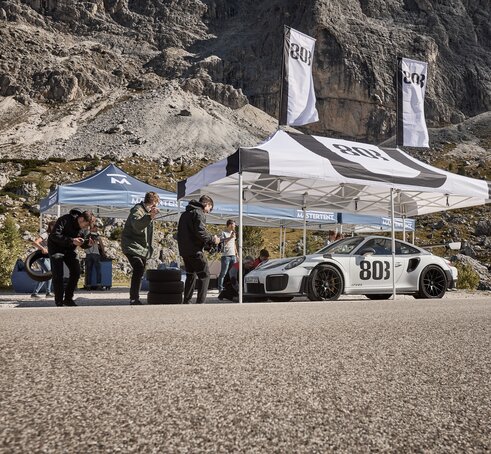 A black and white 20x10 canopy tent with custom printing shades cars.