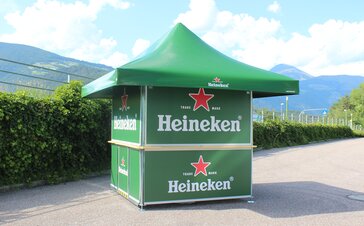 Green Heineken branded pavilion set up with mountain range in the background.