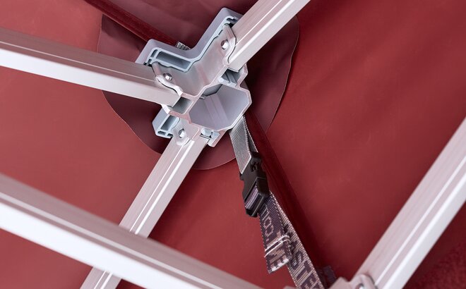 angled view of metal canopy tent framework with burgundy fabric