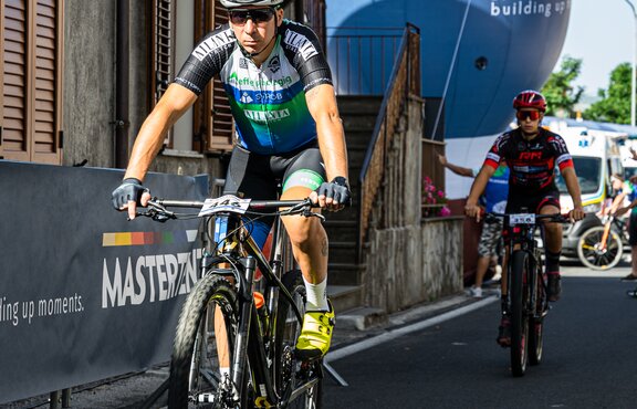 Cyclists racing in front of a Mastertent branded custom inflatable.  | © Andrea  Turillo Photography