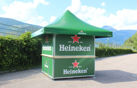 Green Heineken branded pavilion set up with mountain range in the background.