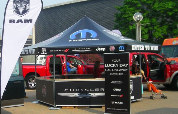 Mopar branded octagonal pavilion set up amidst trucks and flags. 
