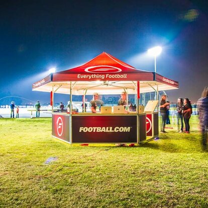 Football.com branded hexagonal pavilion set up on soccer field. 
