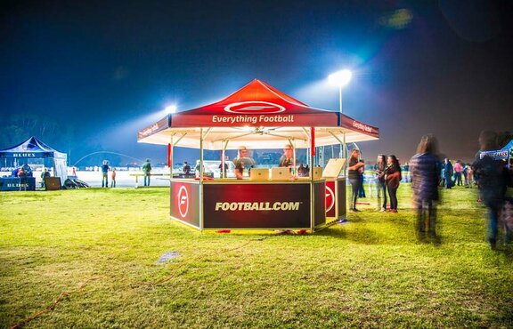 Football.com branded hexagonal pavilion set up on soccer field. 