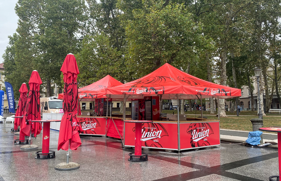 Red Union branded pavilions set up with matching umbrellas. 
