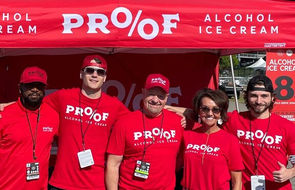A company team in front of a printed red Mastertent Canopy tent.
