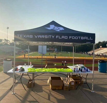 A 10x10ft Mastertent canopy tent set up on a football field for a flag football game.