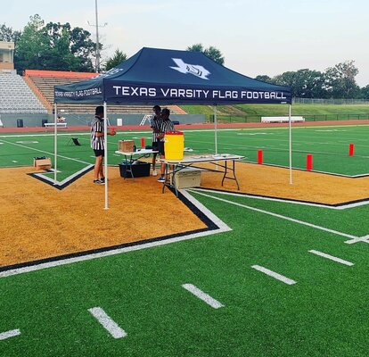 A 10x10ft Mastertent canopy tent set up on a football field for a flag football game.