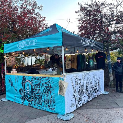 A fully printed Mastertent canopy tent set up as a sales booth.