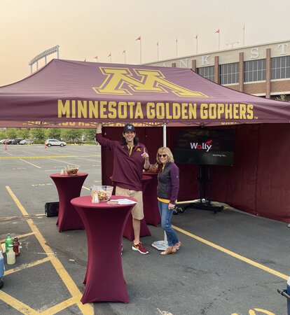 Custom university tailgate tent with coordinated colors, printed roof and sidewalls at a campus event.