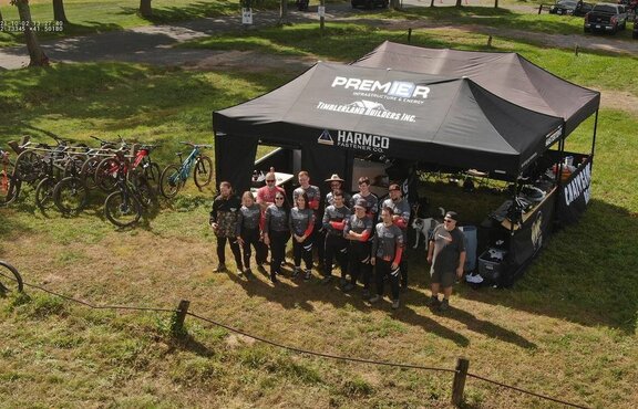Two black canopy tents set up at a bike racing event. 