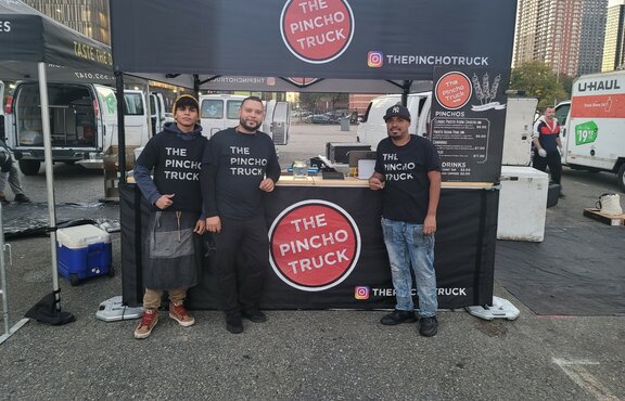 A custom 10x10 food service tent with a wood counter and half sidewalls. 