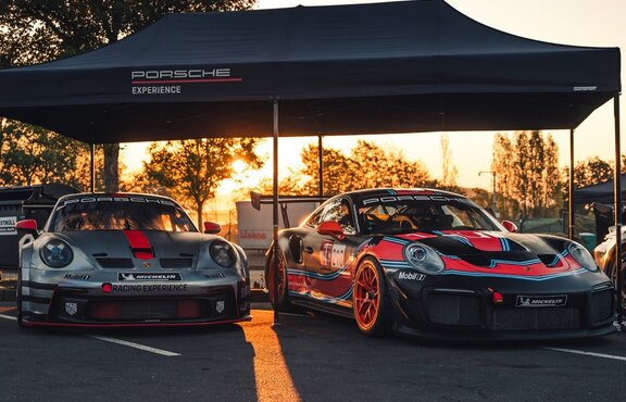 A black 20x10 canopy tent with custom printing and a black frame shades cars. 