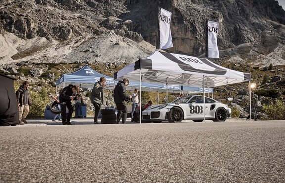 A black and white 20x10 canopy tent with custom printing shades cars.