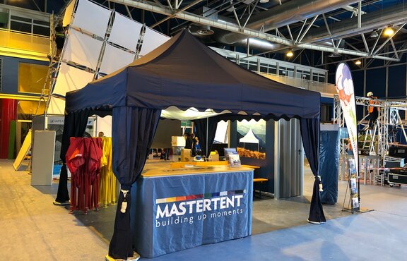 A 17x17 trade show tent indoors with canopy curtains and tent ceiling. 