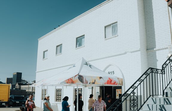 A group of women stand under a 10x10 nonprofit tent with custom printing and a tent awning. 
