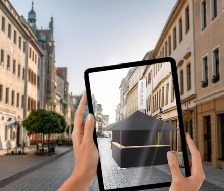 Configuration of a folding pavilion displayed on a tablet as a visualisation in a city centre