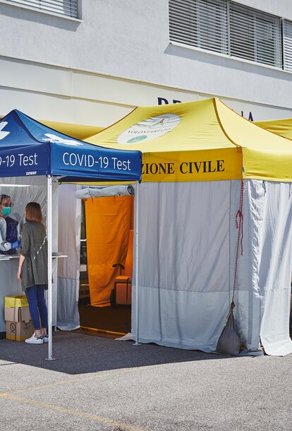 The test cabin for Covid-19 and for measuring fever is located in front of the Brixana Private Clinic. Next to it are two folding pavilions with yellow roofs.