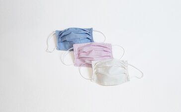 3 fabric masks in the colours light blue, pink and white