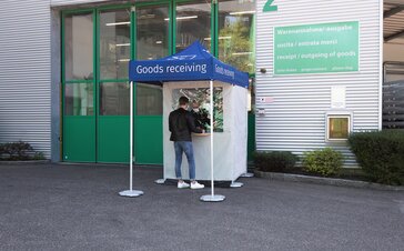 Goods receiving station in front of the warehouse of a company. There is a man at the station.