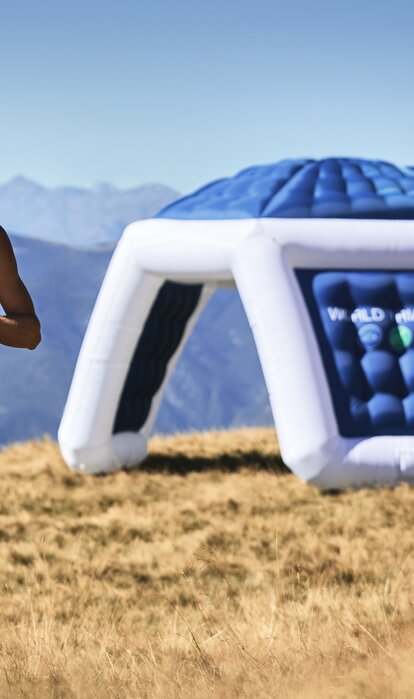 Un atleta sta correndo vicino ad un gonfiabile con la scritta "WORLD TRIATHLON".