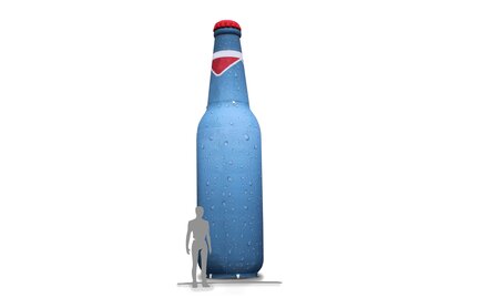 Un gonfiabile a forma di bottiglia su sfondo bianco. Una sagoma di una persona è stata piazzata vicino al gonfiabile per comparare la grandezza.