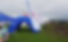 Blue inflatable event tent in a green meadow at an event.