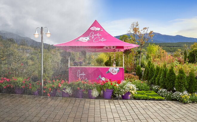 A pink gazebo with awning is located at a flower shop outdoors. It is resistant to all weather conditions. 