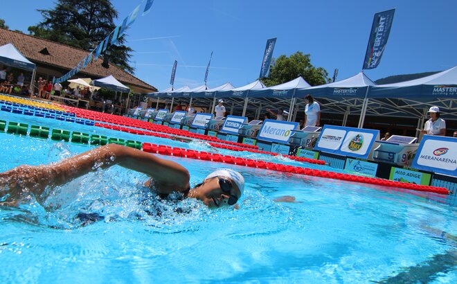 Ein Schwimmbad mit abgetrennten Rennbahnen, in welches Schwimmer hineinspringen. 