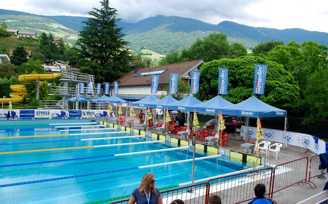 Das Bild zeigt ein Schwimmbad mit 9 Rennbahnen und blauen MASTERTENT Faltpavillons als Unterstand für die Schiedsrichter.