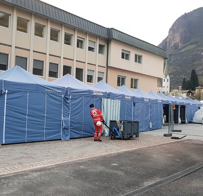 Blaue Faltpavillons von Mastertent bilden einen langen Korridor vor dem Krankenhaus Bozen zur Bekämpfung des Coronavirus.