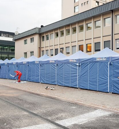 Blaue Faltpavillons von Mastertent bilden einen langen Korridor vor dem Krankenhaus Bozen zur Bekämpfung des Coronavirus.