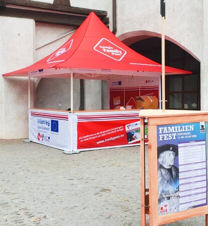 Il gazebo pieghevole promozionale completamente personalizzato Euregio Family Pass di fronte ad un muro.