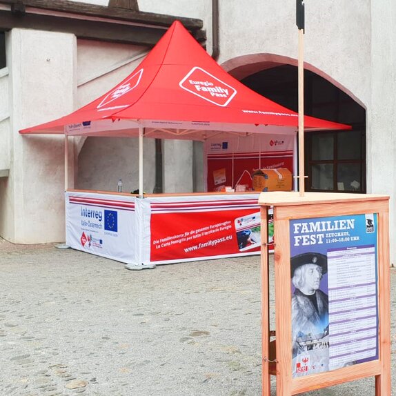 Il gazebo pieghevole promozionale completamente personalizzato Euregio Family Pass di fronte ad un muro.