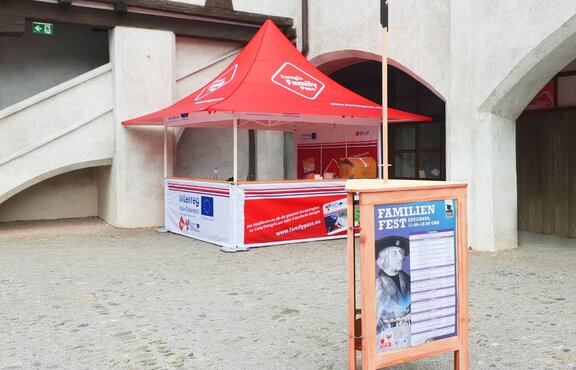 Il gazebo pieghevole promozionale completamente personalizzato Euregio Family Pass di fronte ad un muro.