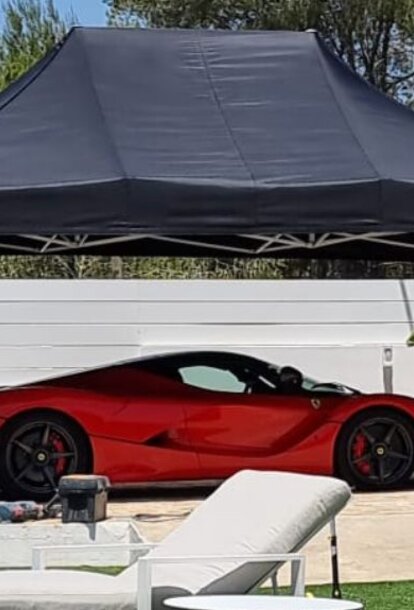 Black 4.5x3m Mastertent car gazebo with red Ferrari on luxury garden with pool