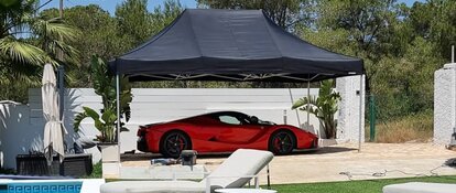Tente pour voiture noir 4,5x3 m Mastertent avec Ferrari rouge dans un jardin luxueux avec piscine