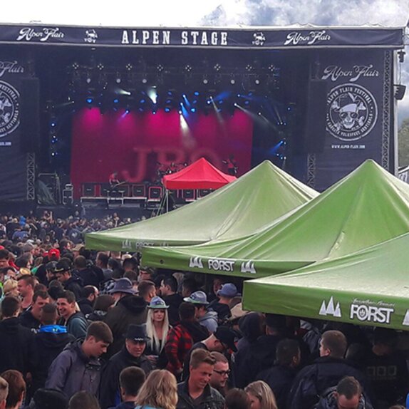 Bühne beim Alpen Flair Festival. In der Menschenmenge stehen die Pavillons von MASTERTENT.