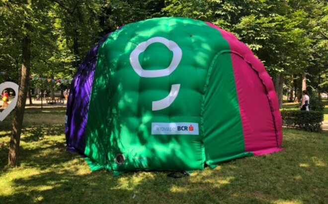A colourful inflatable tent is located in the meadow. It is printed with the logo of George, BCR. 