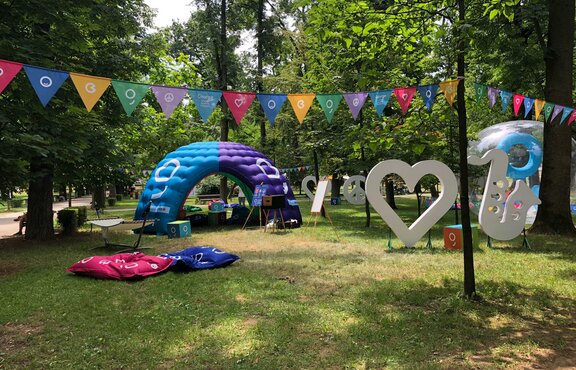 An inflatable tent is located at the Jazz in the Park Festival. It is colourful and big. It serves as a chill lounge and promotion corner. 