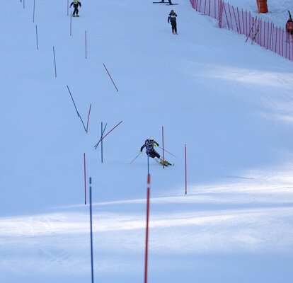 Die Skiläuferin fährt gerade durch den gesteckten Slalom.