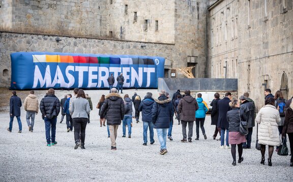 Meeting in der Festung Franzensfeste Die Vertreter befinden sich im Gelände der Festung Franzensfeste und gehen auf einen aufblasbaren MASTERTENT Werbeträger zu.