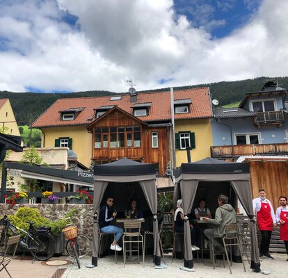 Due gazebo Loden di Mastertent sono situati sulla terrazza di un bistrò. Servono come tende per il catering. I clienti si godono le bevande sotto.  